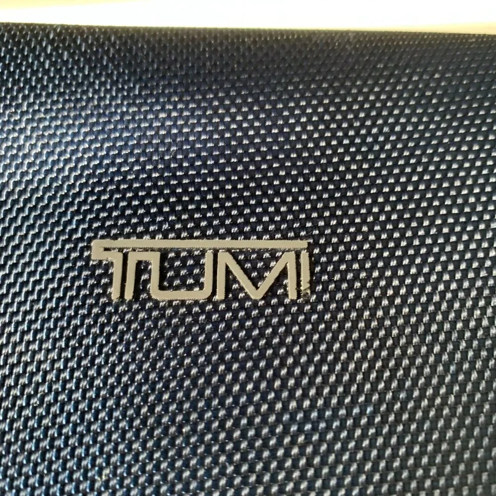 The product is a navy blue hard case amenity kit bag by TUMI for Delta Airlines.